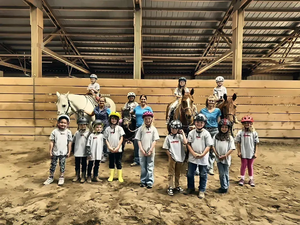 Young riders with their horses and ponies in the arena