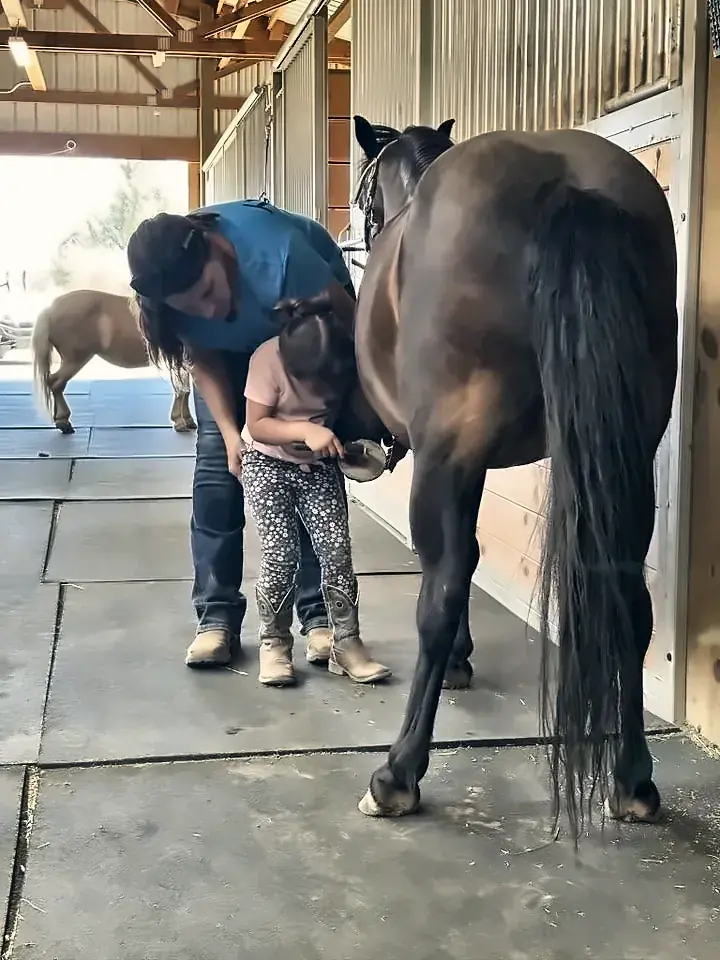 Tanya teaching a young student to pick up a hoof