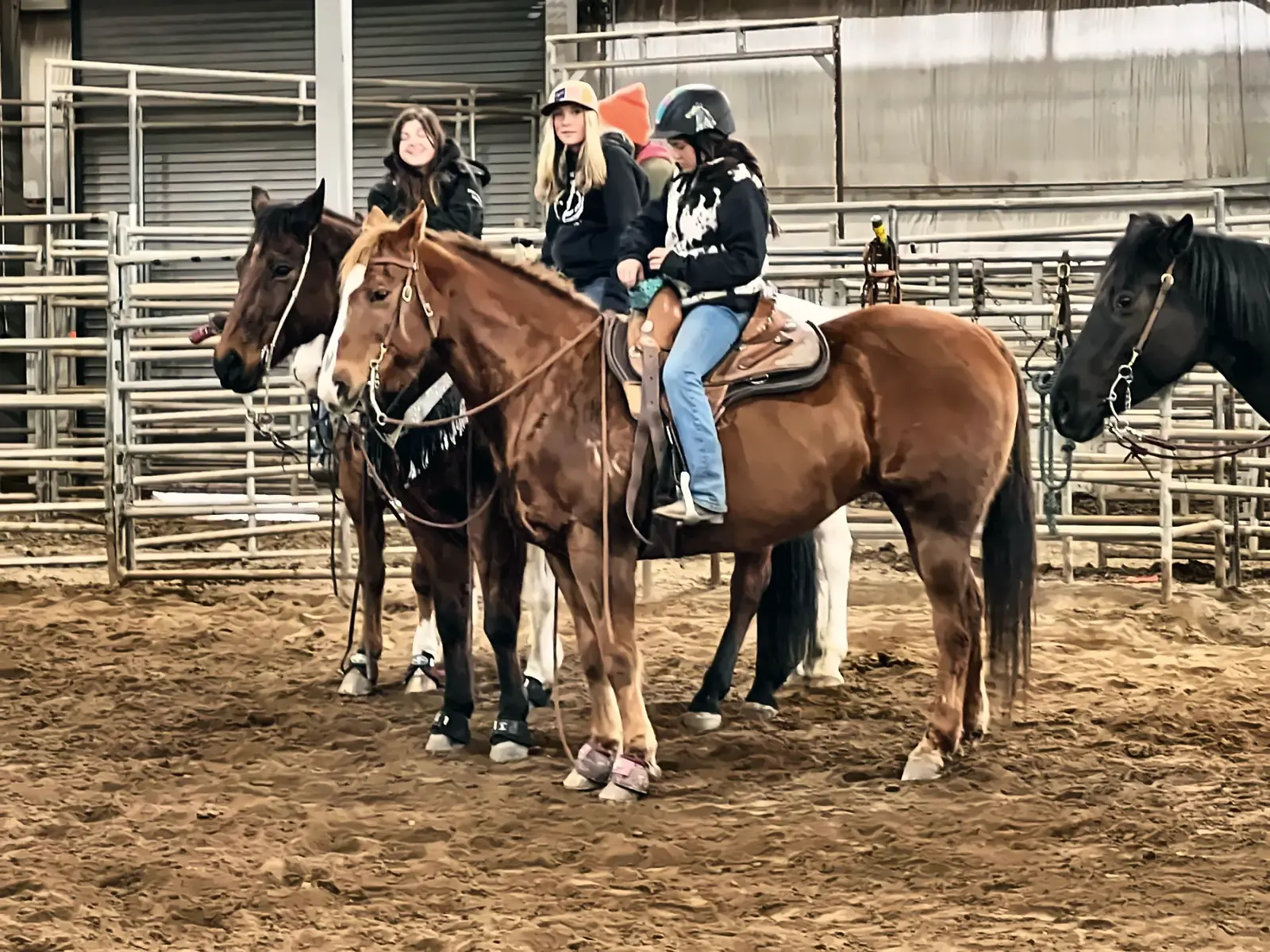 Young riders on horseback in the arena