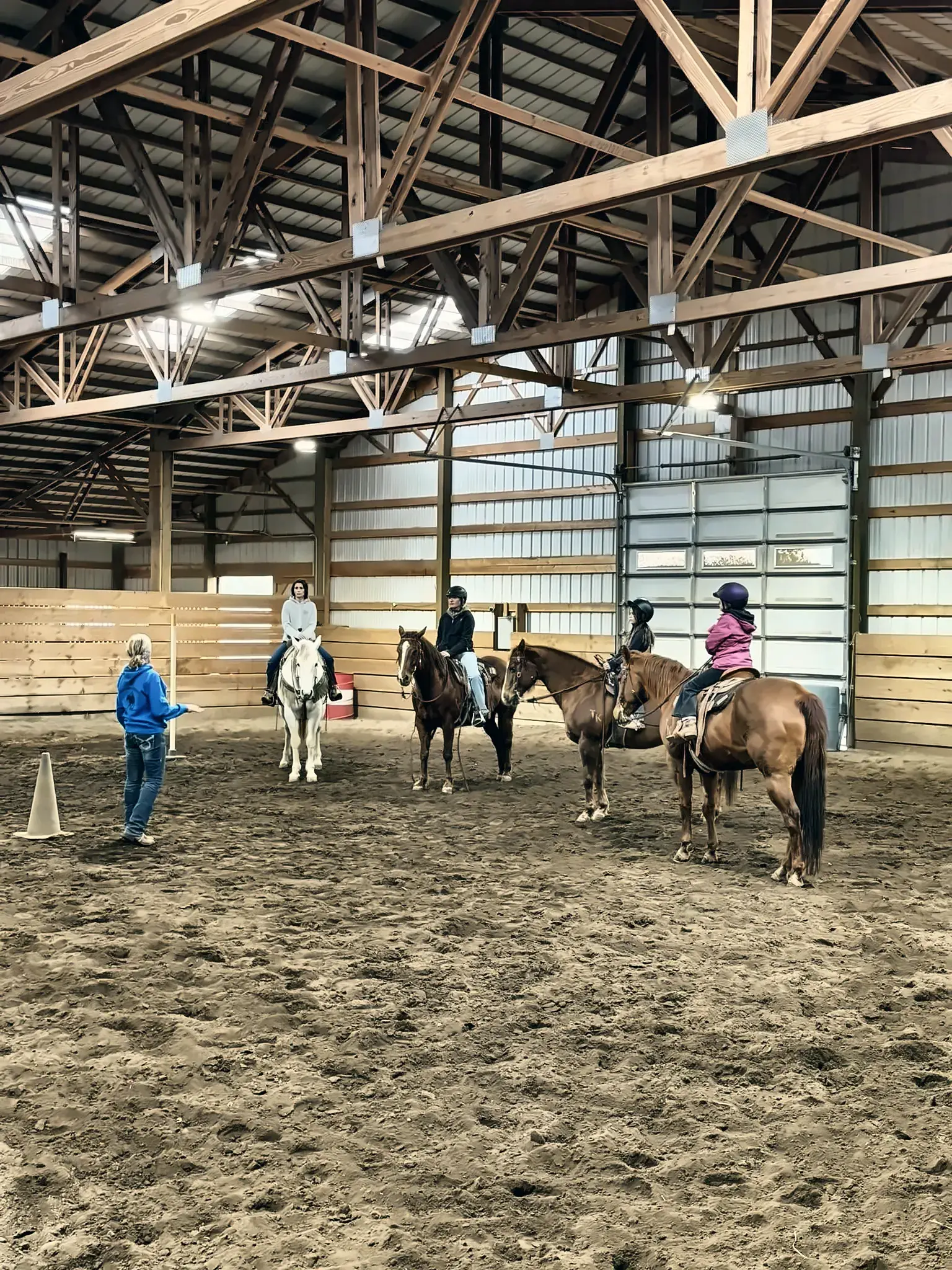 Students riding in a lesson in the indoor arena